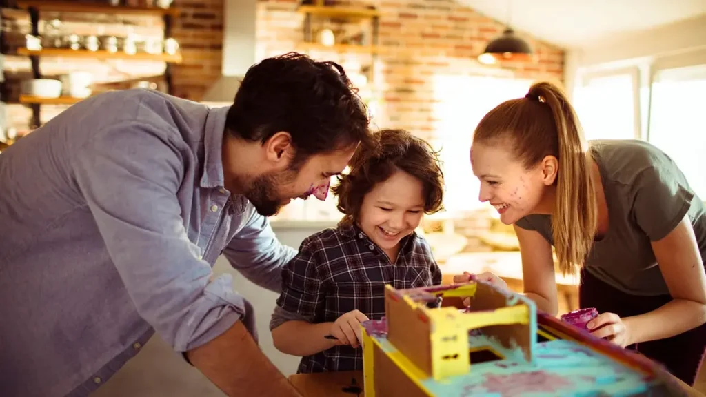 Smiling toddler playing and learning with supportive parents.
