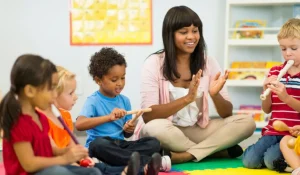 A preschool teacher engaging with young children through interactive learning activities in a bright, welcoming classroom.