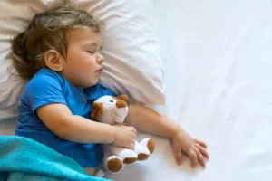Toddler sleeping peacefully with a cozy blanket, ensuring healthy growth and development.